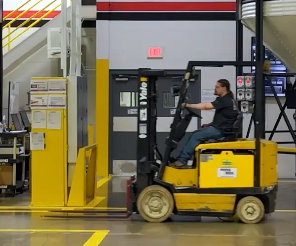GHCM forklift operator driving a yellow forklift in the plant