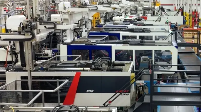 Panoramic view of injection molding machines and conveyors on the GHCM plant floor